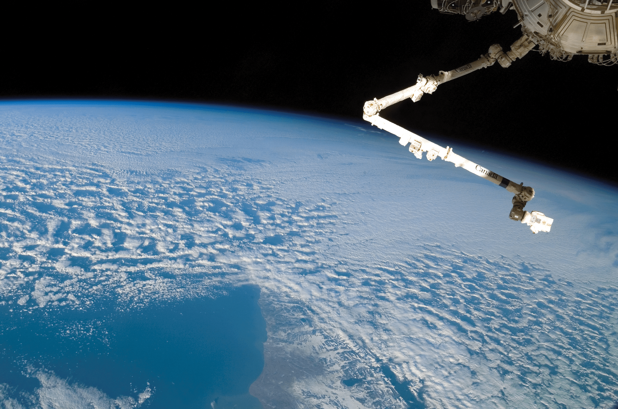 image of a robotic arm with Earth on the backdrop