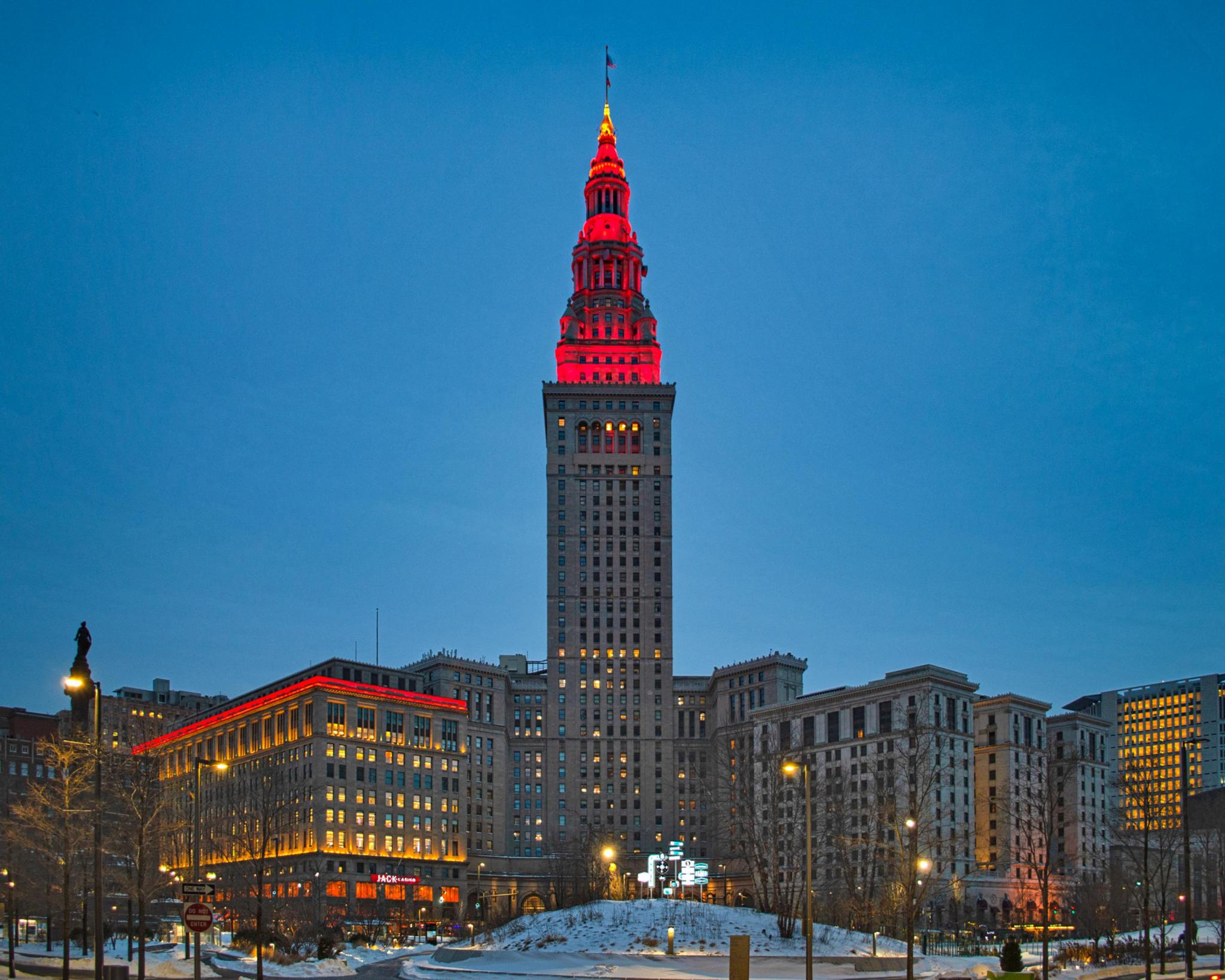 Tall office tower in Cleveland lit up red with outside lights.