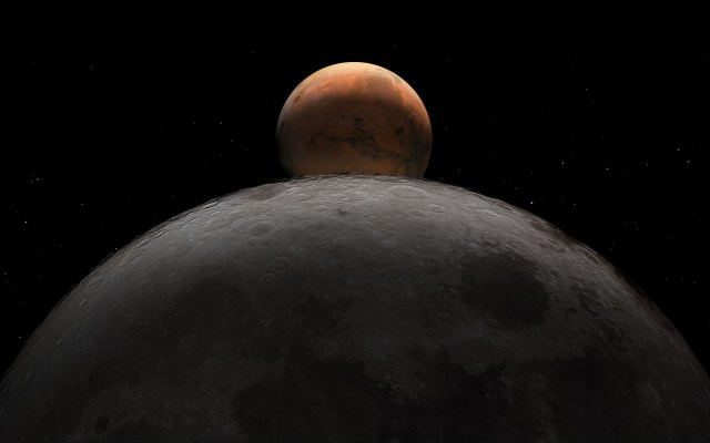 the rusty red sphere of planet Mars rises behind the curved cratered gray surface of the moon suspended in the blackness of space