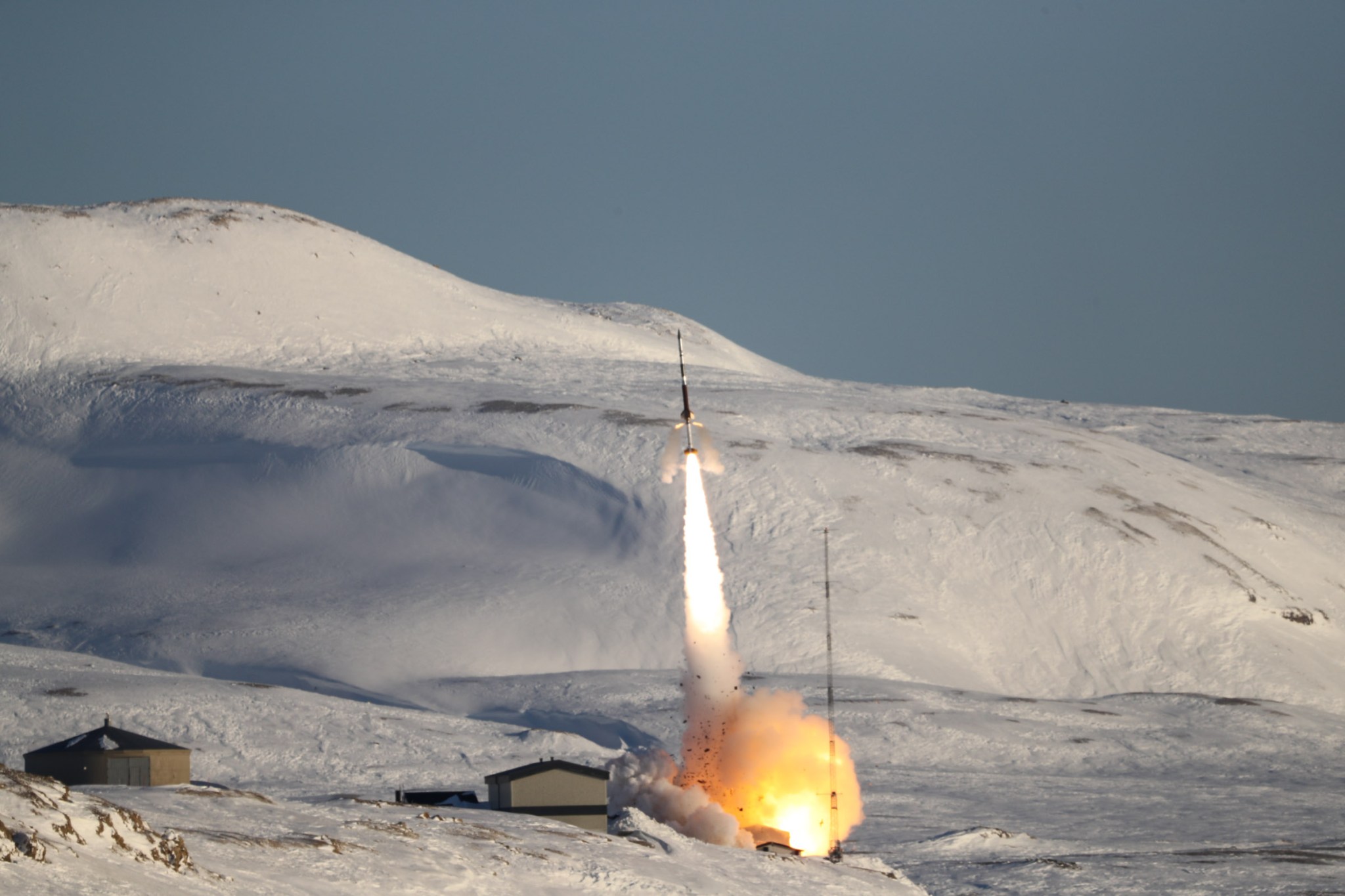 rocket launching against a backdrop of snow-covered mountains