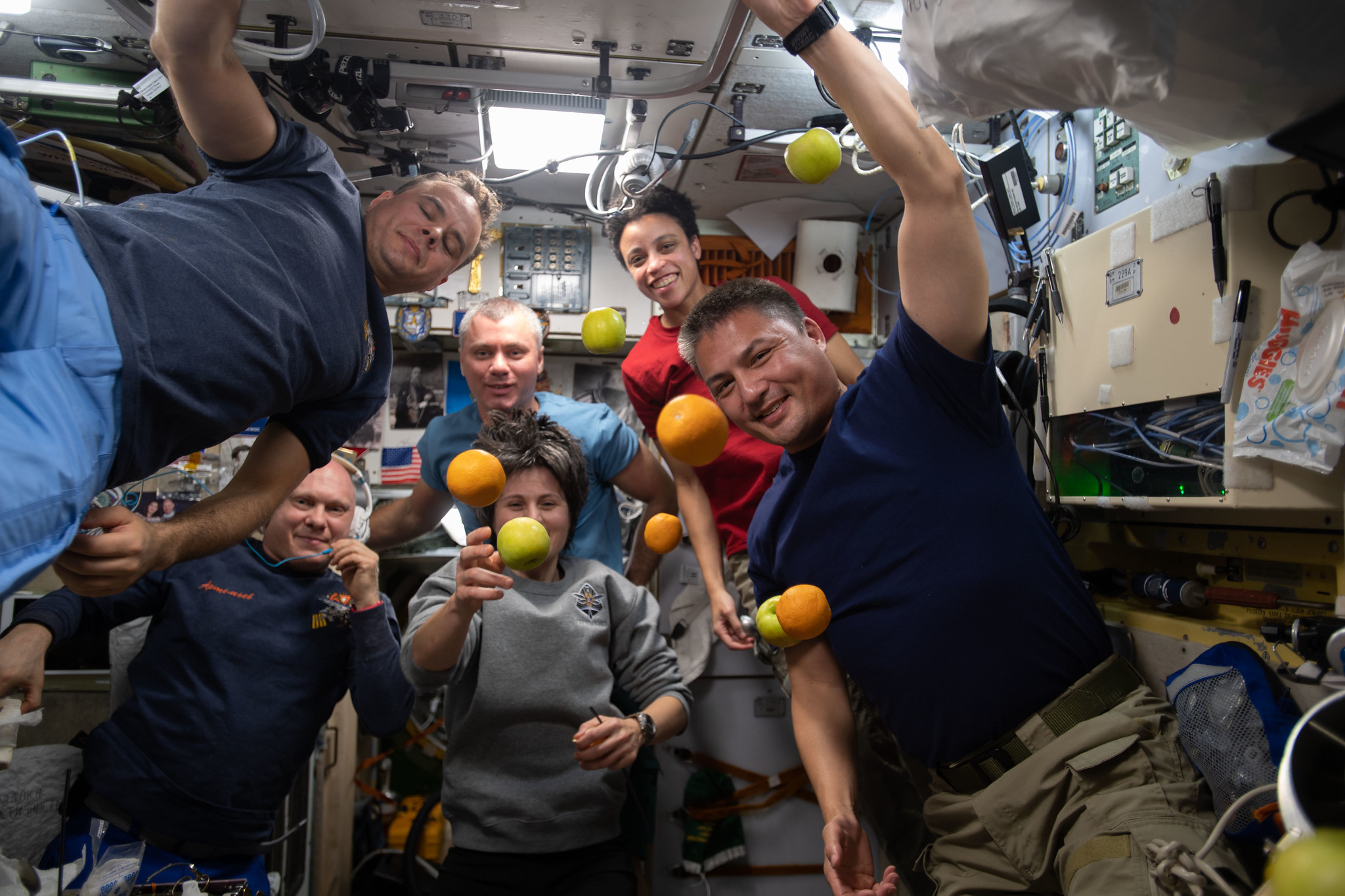 image of crewmembers with floating fruit 