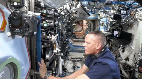 moving image of an astronaut performing maintenance on experiment hardware