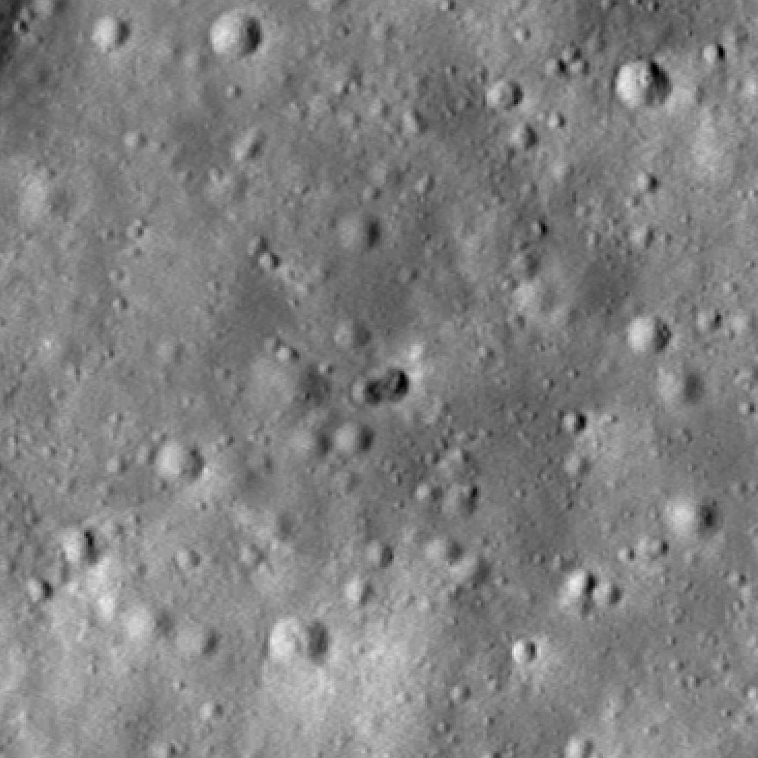 Gif of a rocky, grayscale lunar landscape, as seen from above by LRO. It switches between views of the landscape some time before and some time after an asteroid impact. A dark double crater appears near the center of the image.