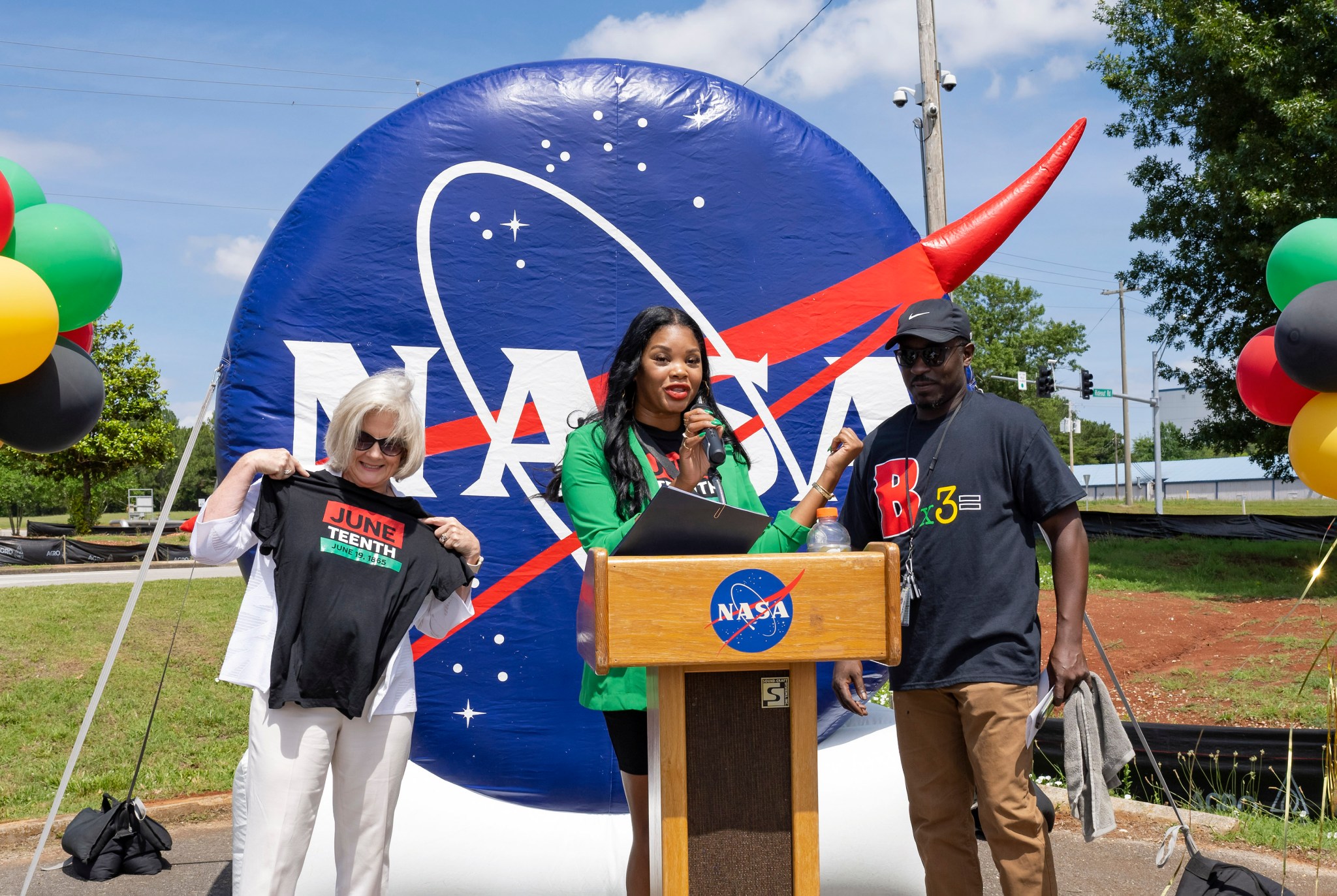 Jody Singer, left, and Nick Benjamin, right, join Amanda Otieno to welcome team members and guests to the center’s first Juneteenth festival.