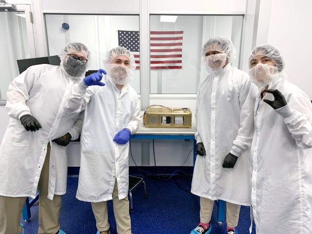 Four engineers from Terran Orbital Corporation pose with the CubeSat Proximity Operations and Demonstration (CPOD) spacecraft at their facility in California.