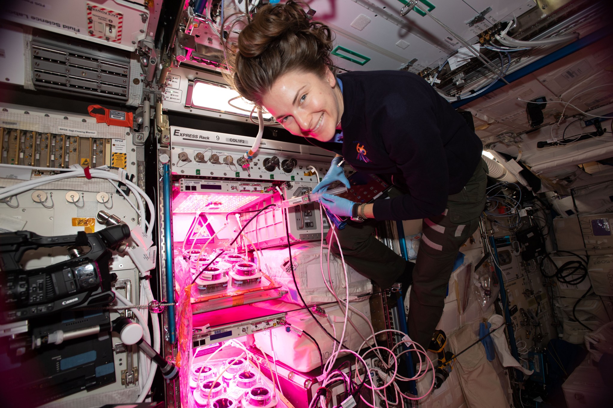 NASA astronaut Kayla Barron monitors experiments in one of the International Space Station’s 12 EXPRESS Racks during Expedition 66.