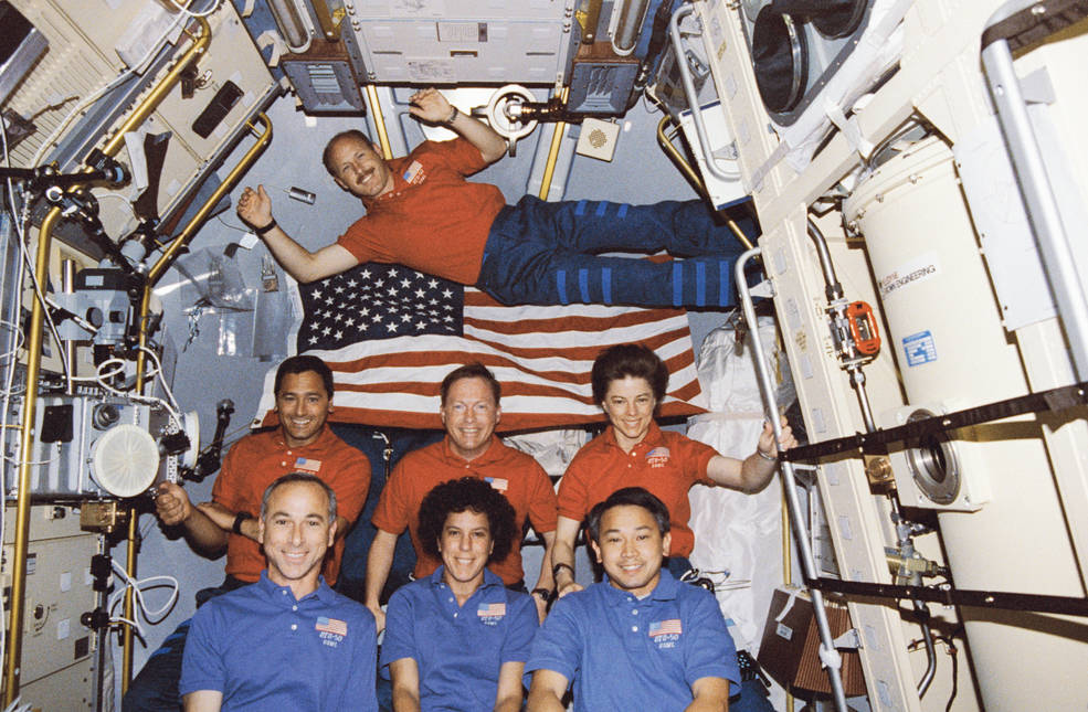 sts_50_inflt_crew_photo_w_flag_jul_1992