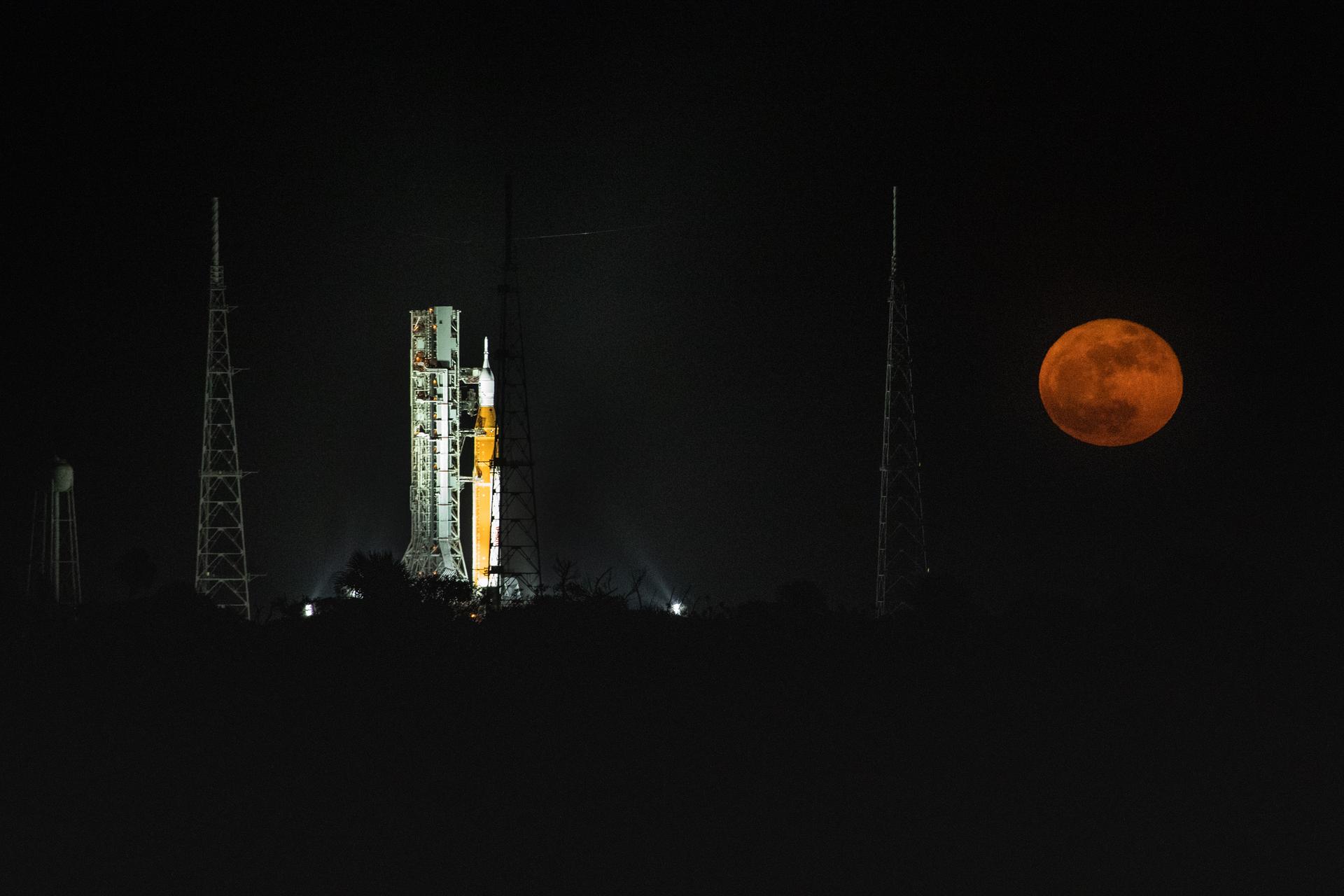 A full Moon in view with the Artemis I Space Launch System rocket and Orion spacecraft at Launch Complex 39 on June 14.