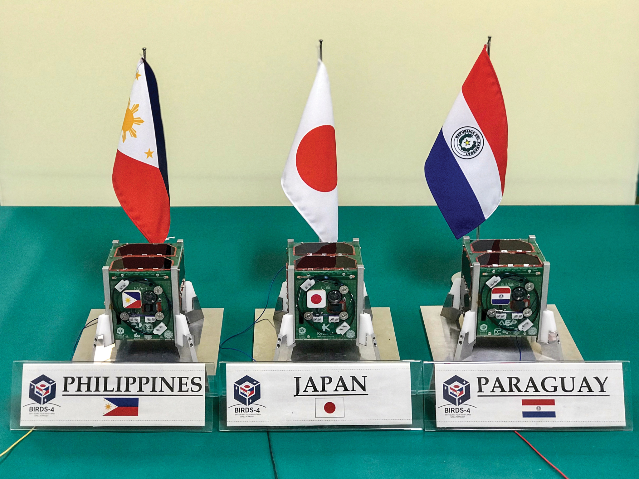 image of three cubesats on a table prior to flight