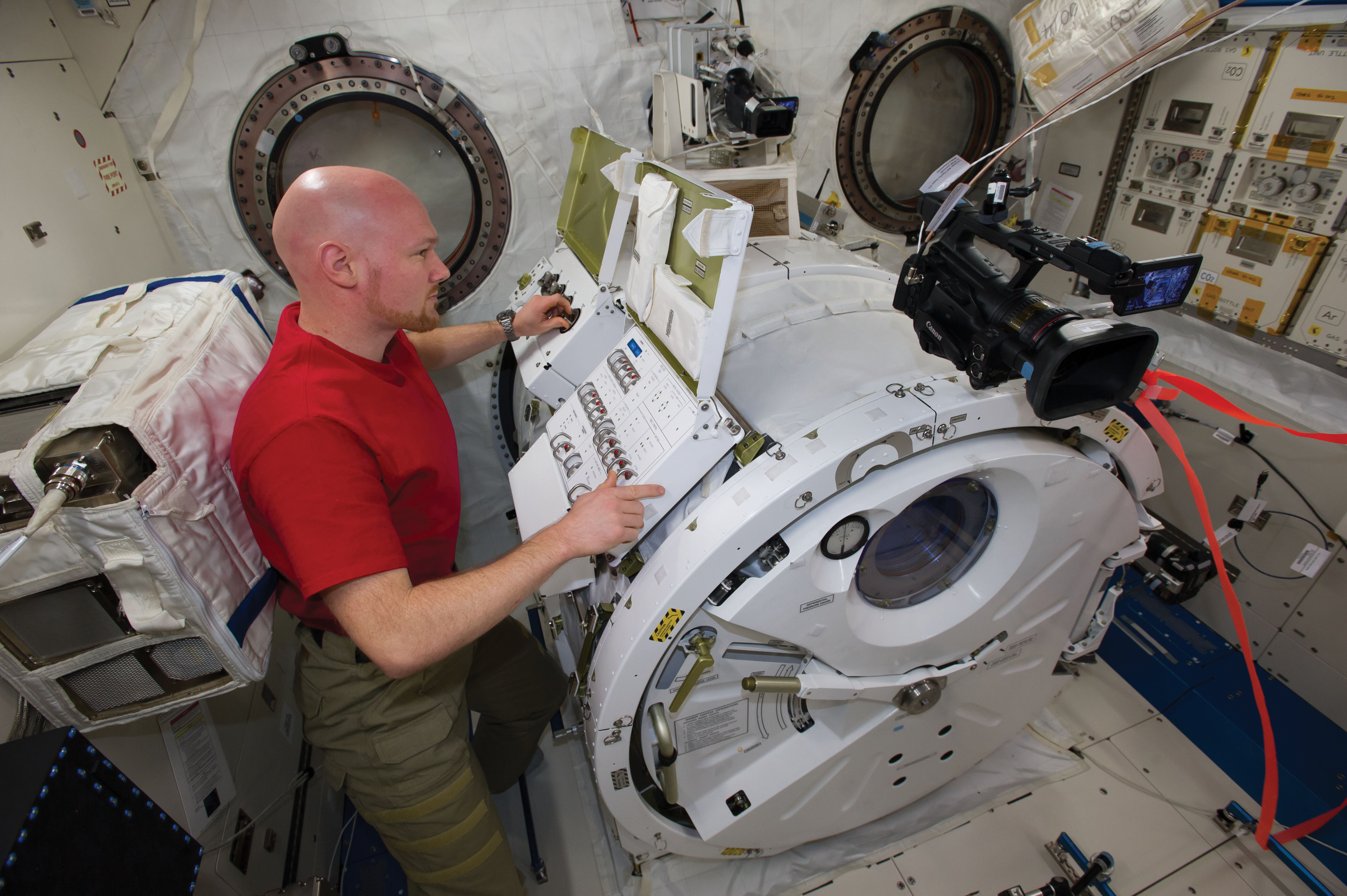 image of an astronaut preparing cubesats for deployment