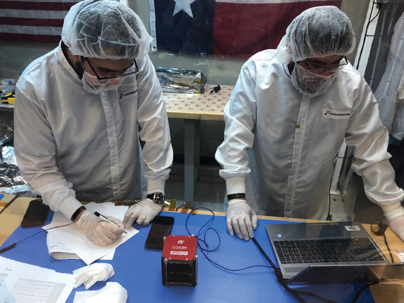 image of student researchers preparing cubesats for flight