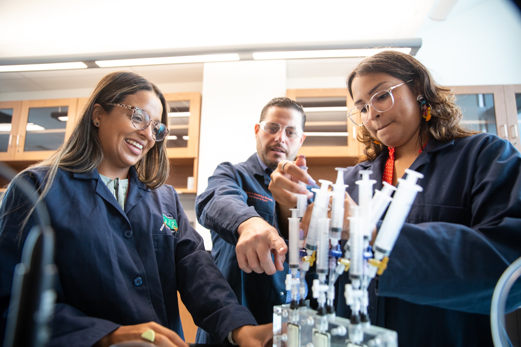 Alondra Rodriguez-Rolon, professor Eduardo Nicolau, and Liz Santiago-Martoral work on one of their water recycling experiments. 