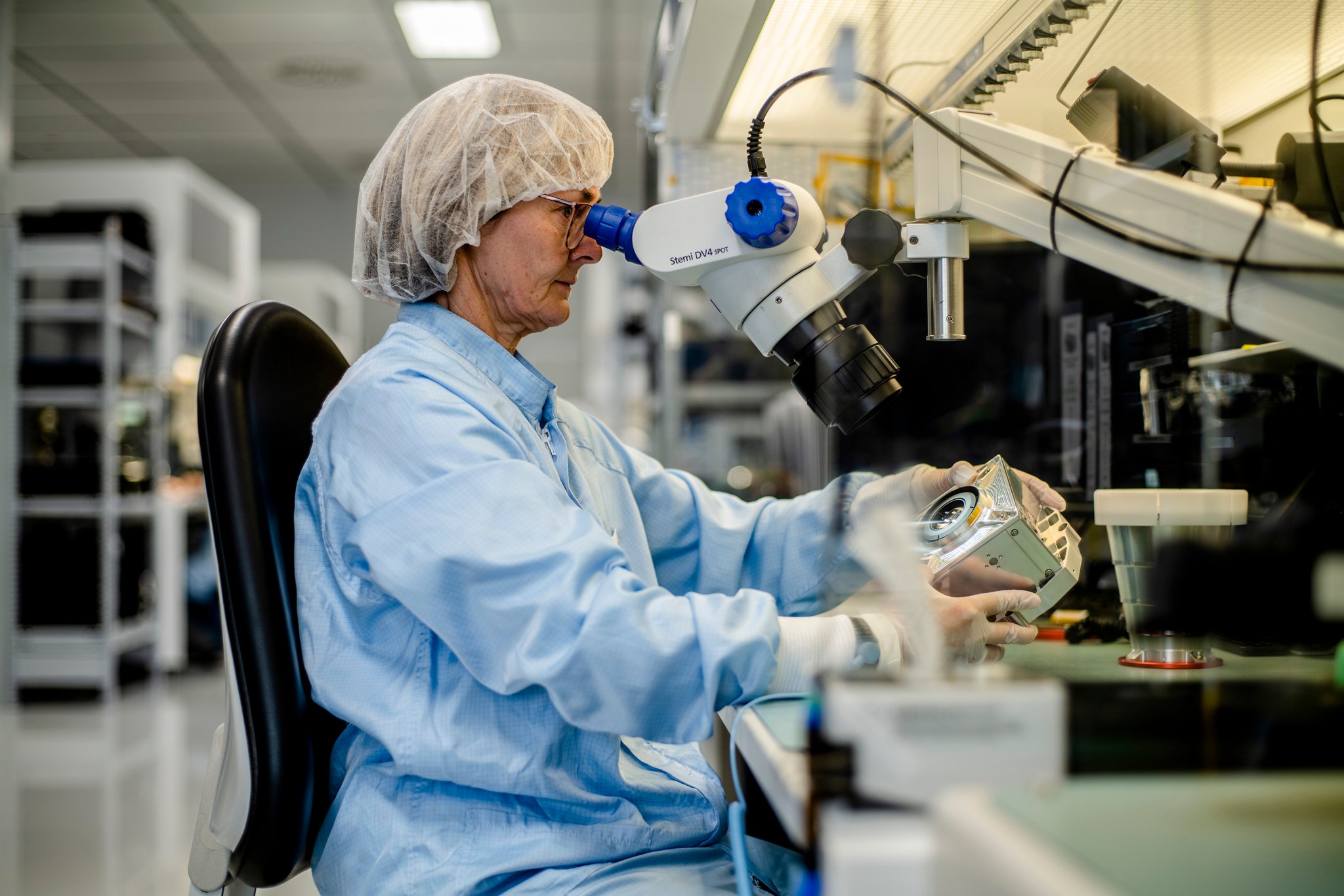 A worker inspecting a star tracker in a lab