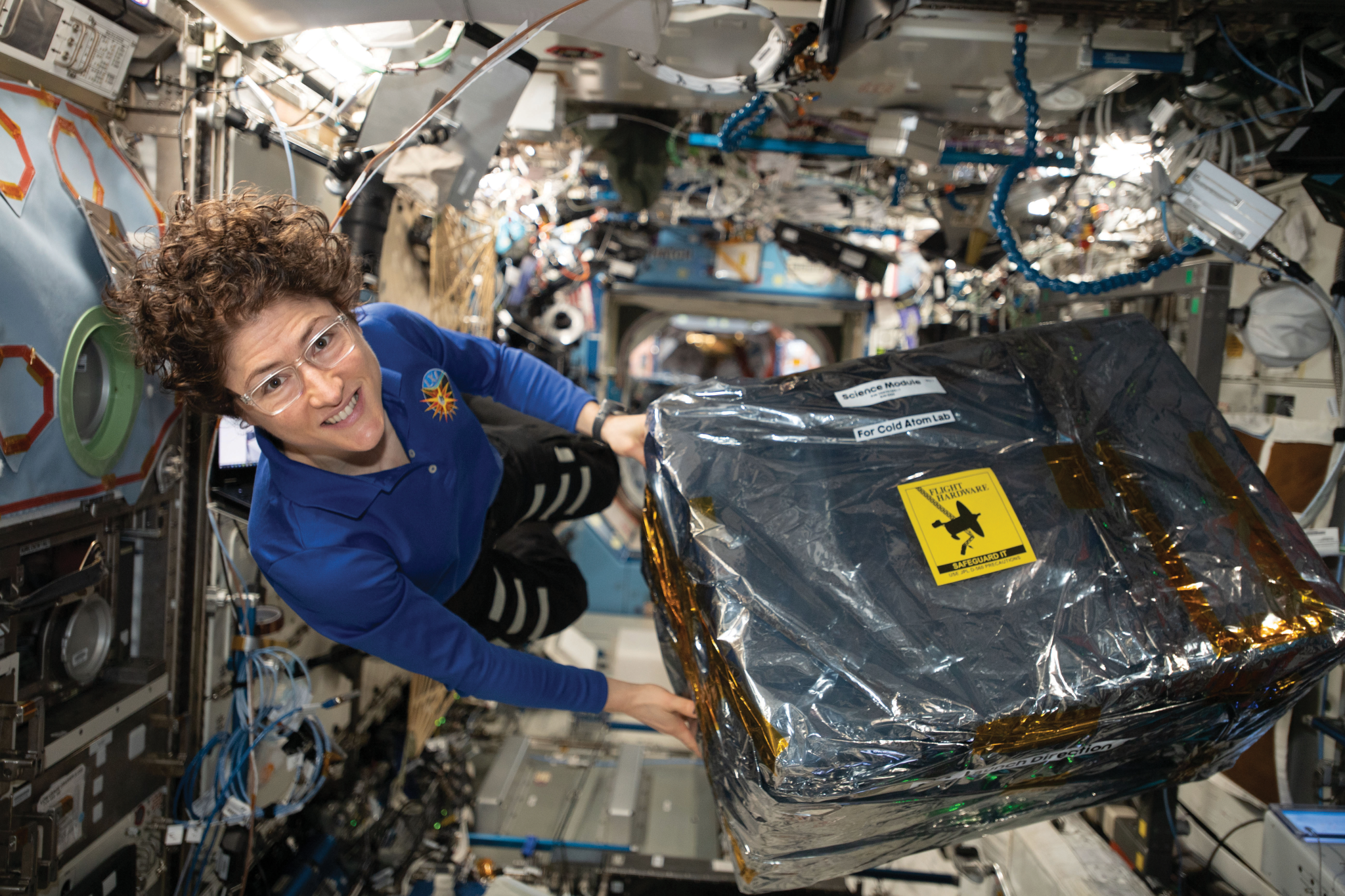 image of an astronaut carrying moving experiment hardware 