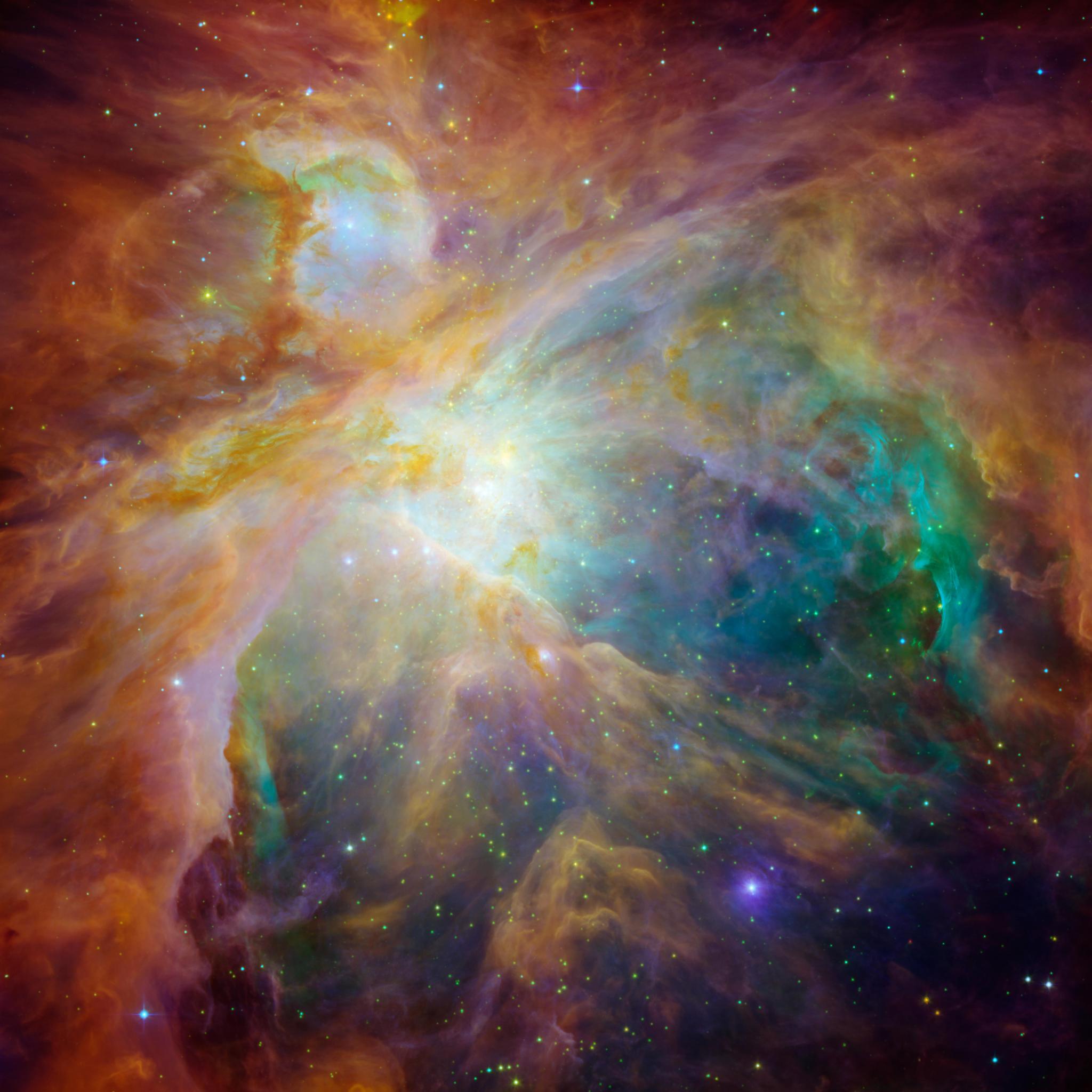 An image of the Orion nebula showing carbon-rich molecules called polycyclic aromatic hydrocarbons (PAHs) as wisps of red and orange 