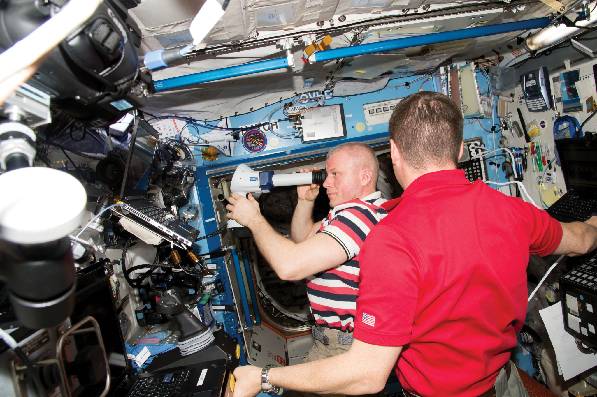 image of two astronauts conducting an eye examination