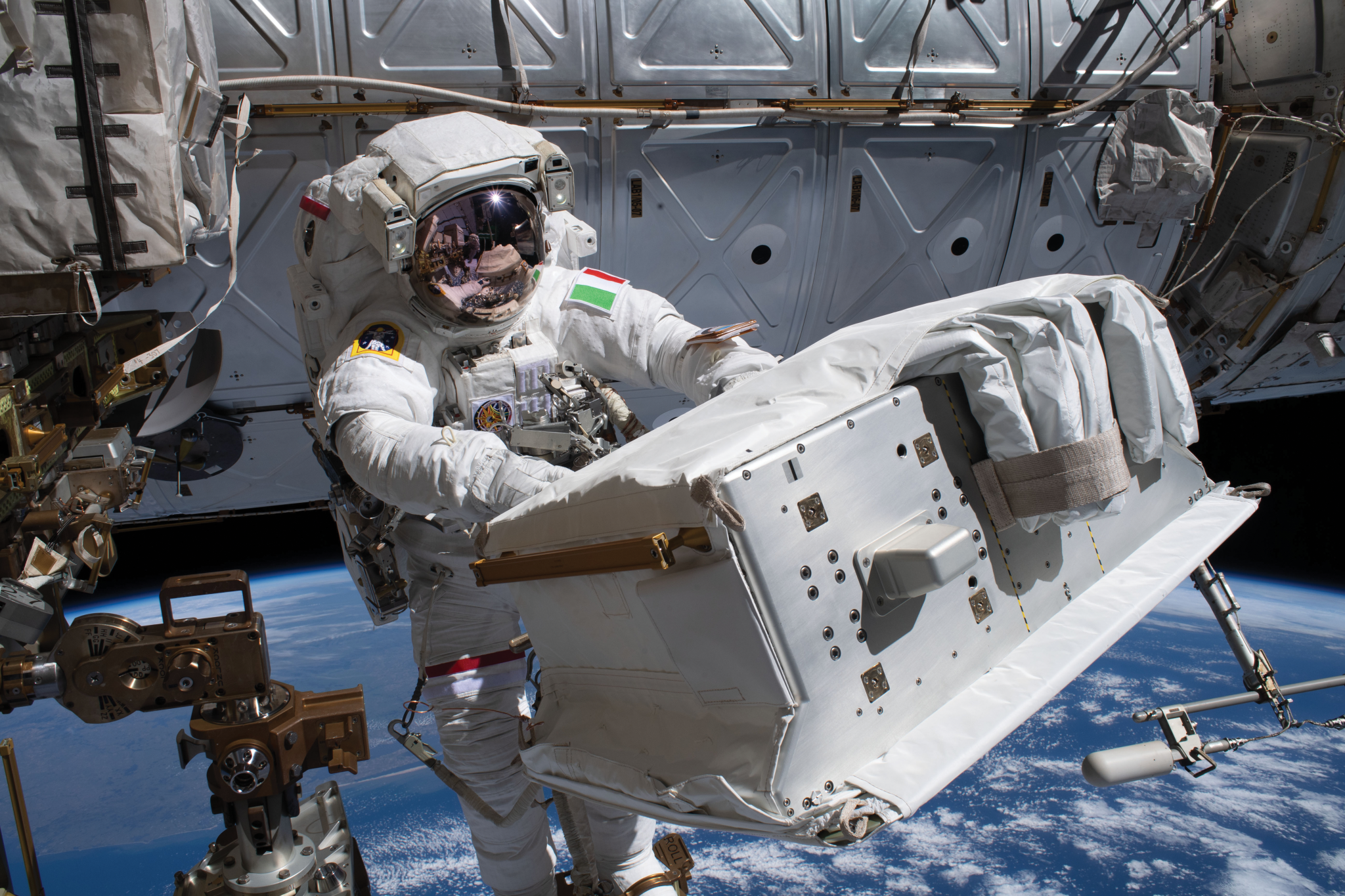 image of an astronaut carrying hardware during a spacewalk