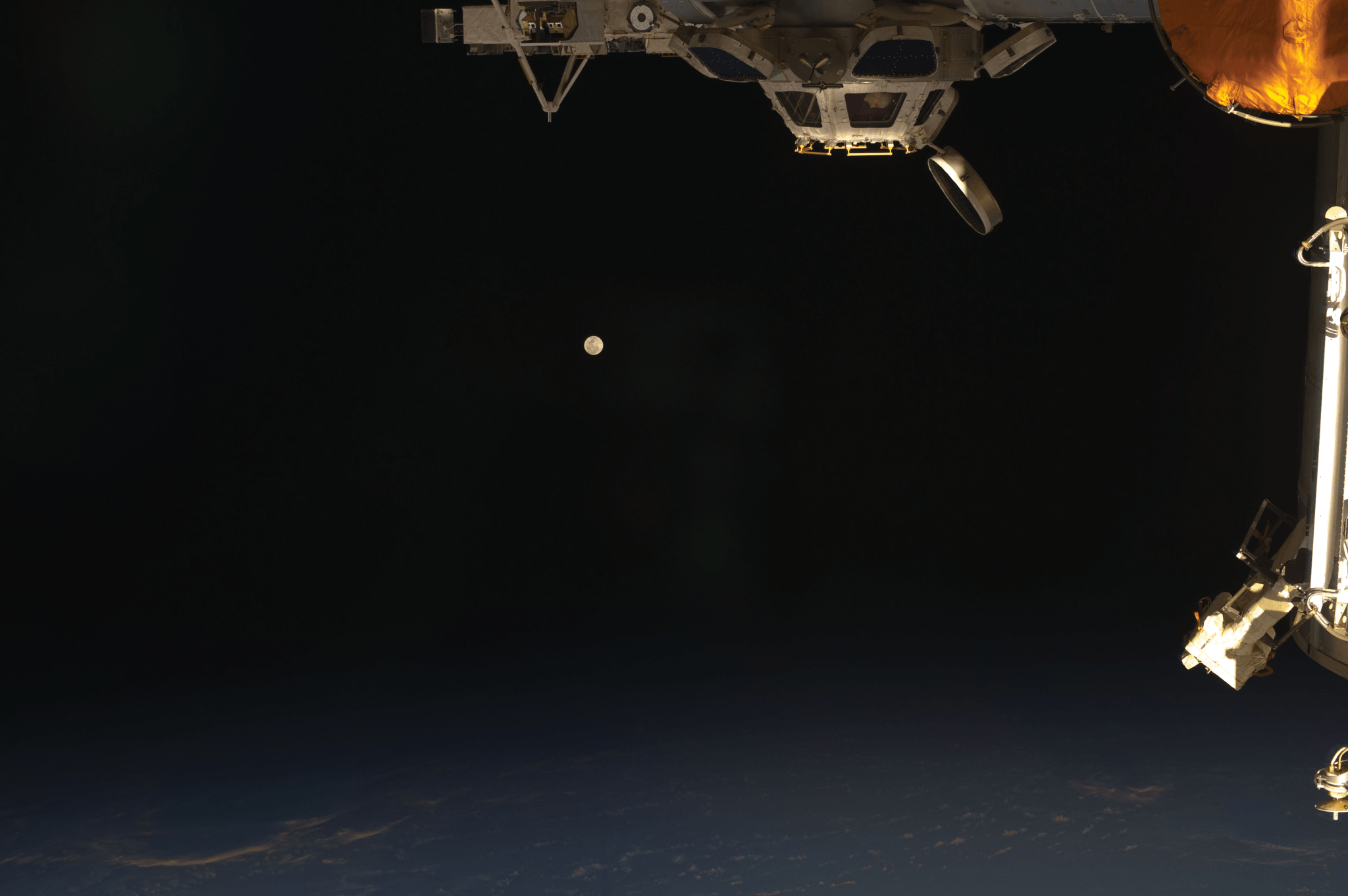 image of the station's cupola with moon at the distance