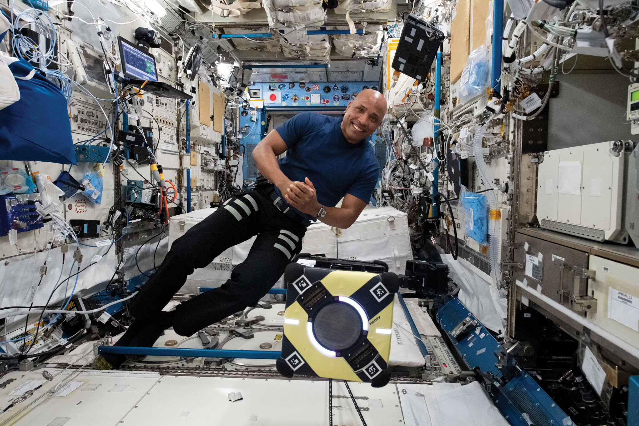 image of an astronaut working with flying robots