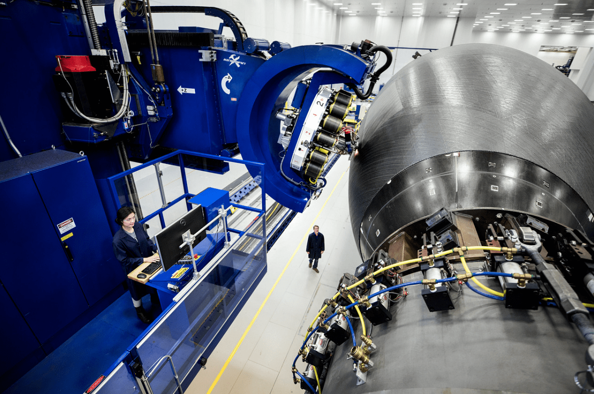 An automated fiber placement machine builds a composite aircraft fuselage.