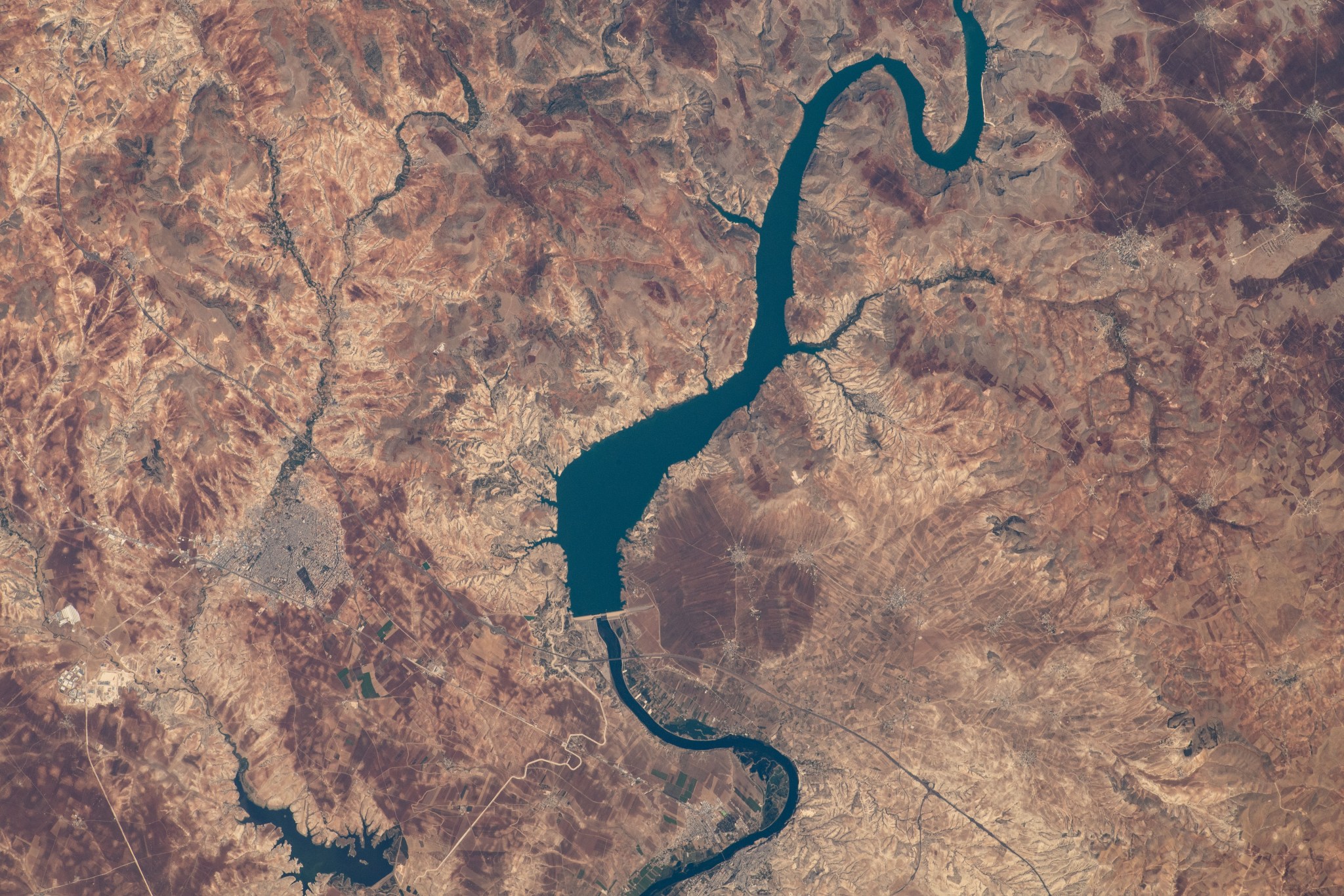 image of a river and a dam surrounded by desert