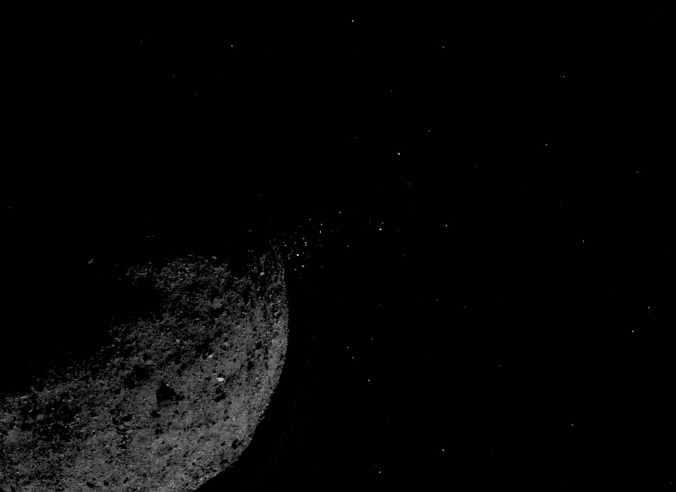 A view of asteroid Bennu ejecting particles from its surface. 