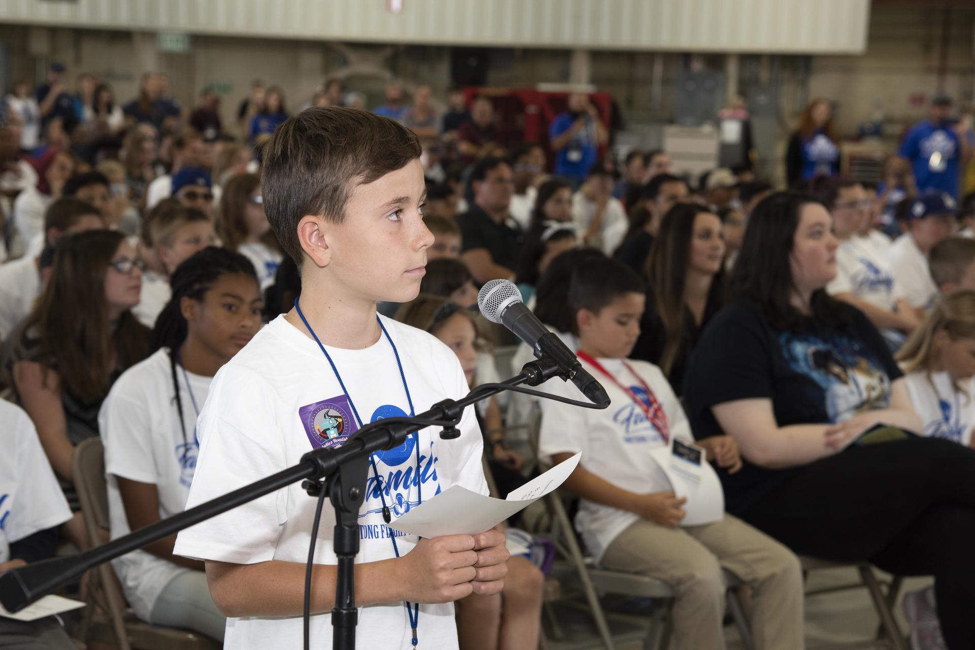 image of a student standing at a microphone
