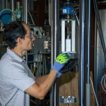 Andrew Holguin prepares an experiment to verify the strength of the magnetic forces as two mounted magnets are moved closer and closer to each other.