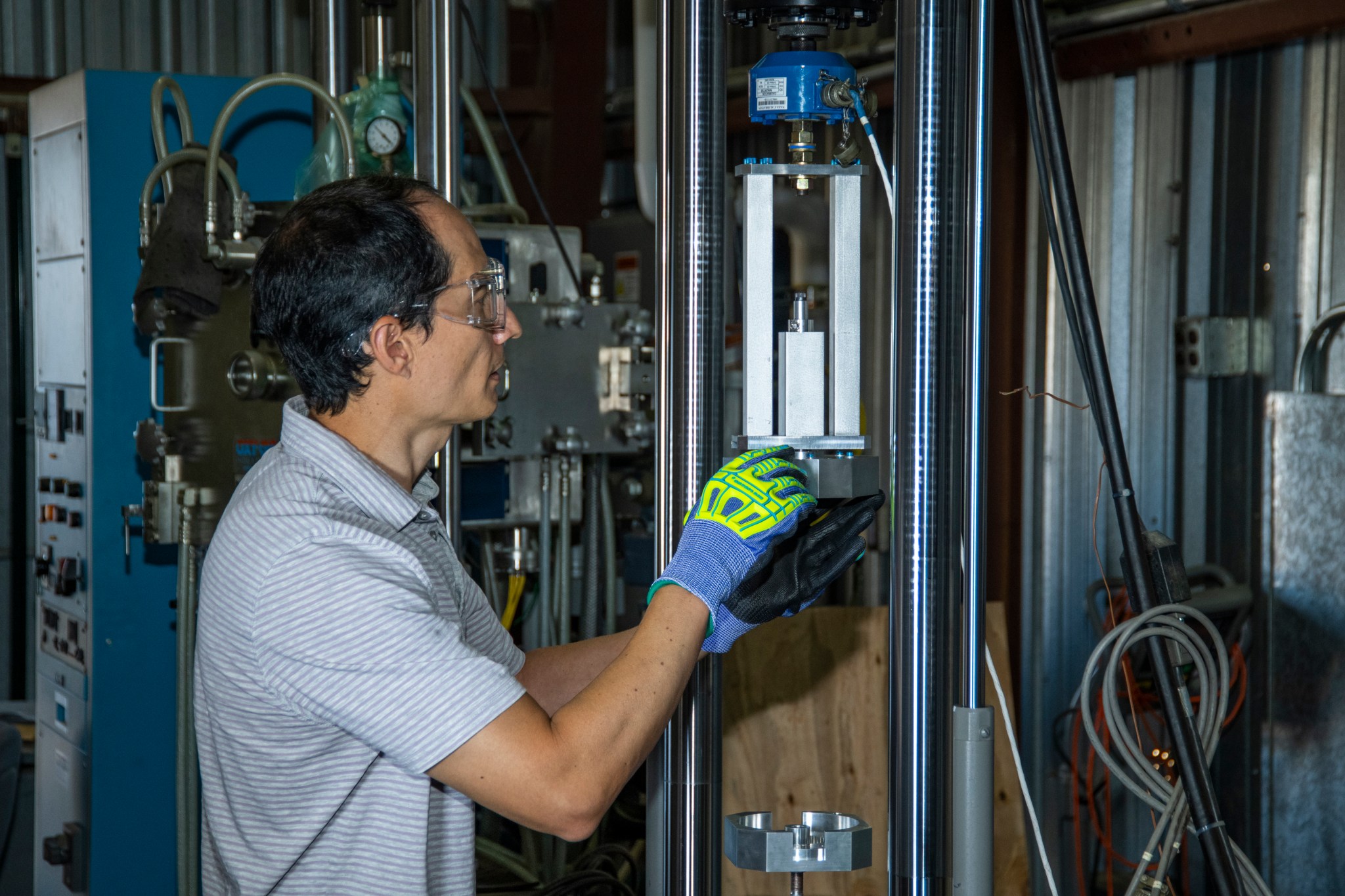Andrew Holguin prepares an experiment to verify the strength of the magnetic forces as two mounted magnets are moved closer and closer to each other.