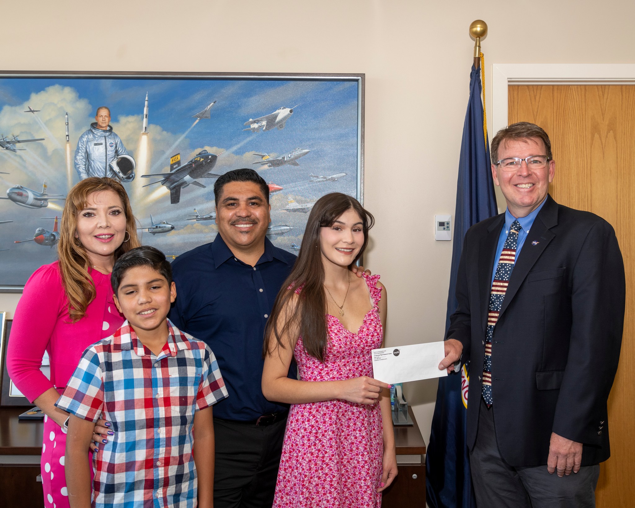 Perez accepts the scholarship from Acting NASA Armstrong Center Director Brad Flick. From left are Annamarie Perez, John Perez, Carlos Perez, Katelyn Perez and Flick.