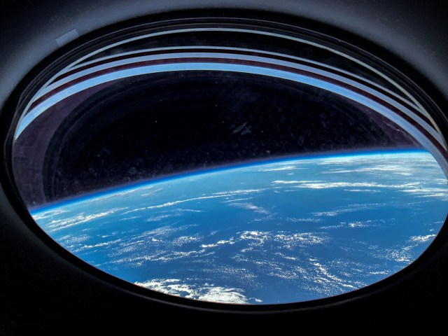 Image of a bright blue ocean on Earth that was captured from a window on the SpaceX Dragon Endurance spacecraft as it approached the International Space Station.