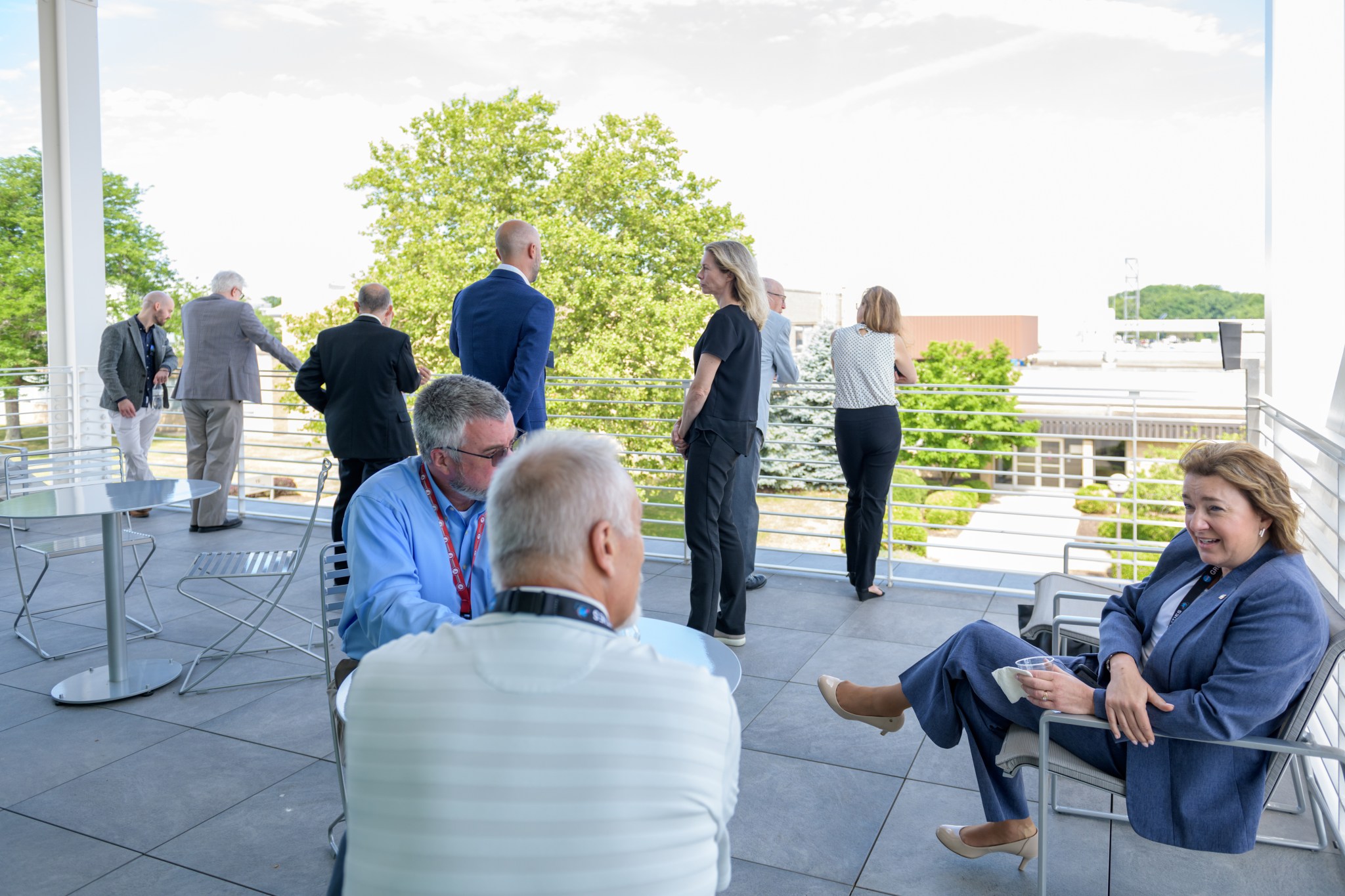 Employees gather on an outdoor balcony overlooking NASA center.