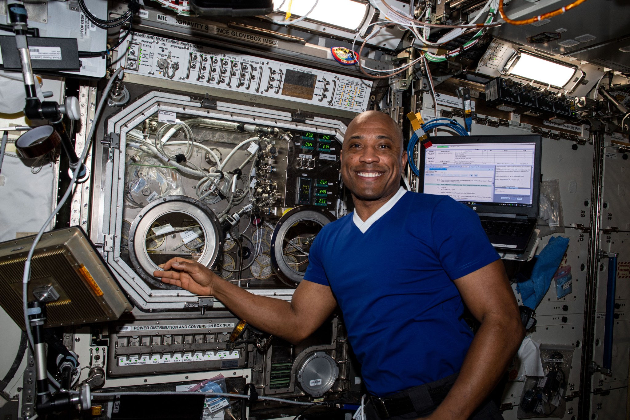 NASA astronaut Victor Glover works with a payload inside the Microgravity Science Glovebox aboard the International Space Station in 2021. 
