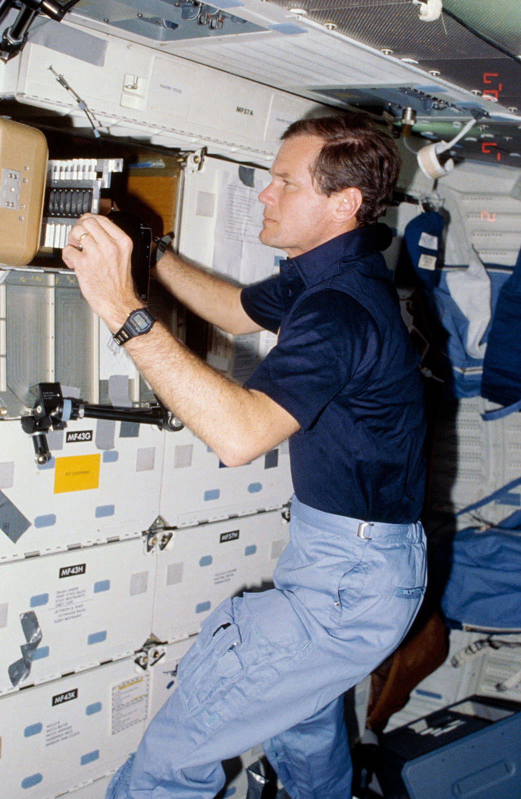 U.S. Representative Bill Nelson (now NASA Administrator), STS-61C payload specialist, prepares to photograph individual samples in the Handheld Protein Crystal Growth Experiment (HPCG) on space shuttle Columbia's middeck. 