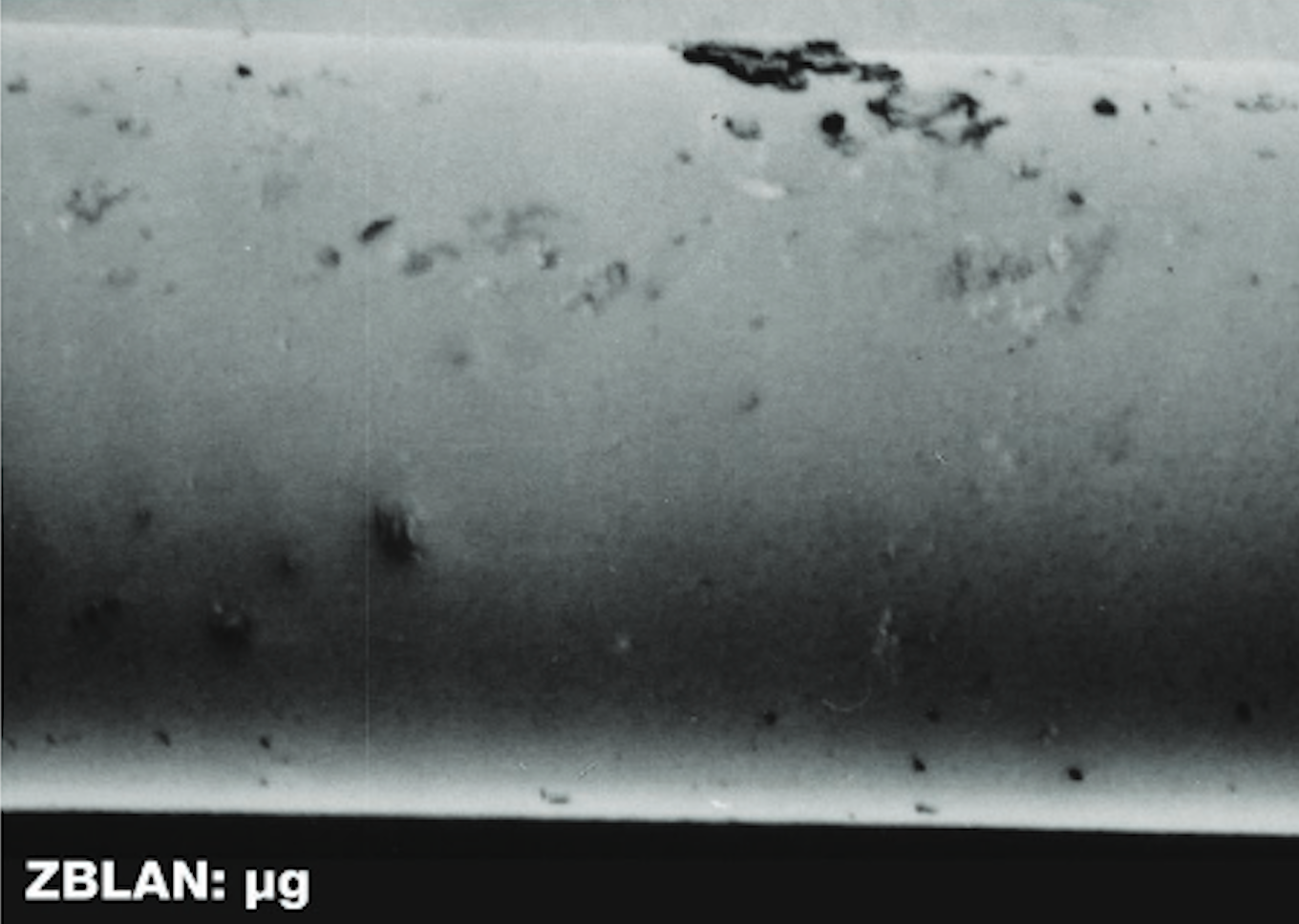 Microscopic view of smooth-surfaced ZBLAN optical fiber produced in microgravity.