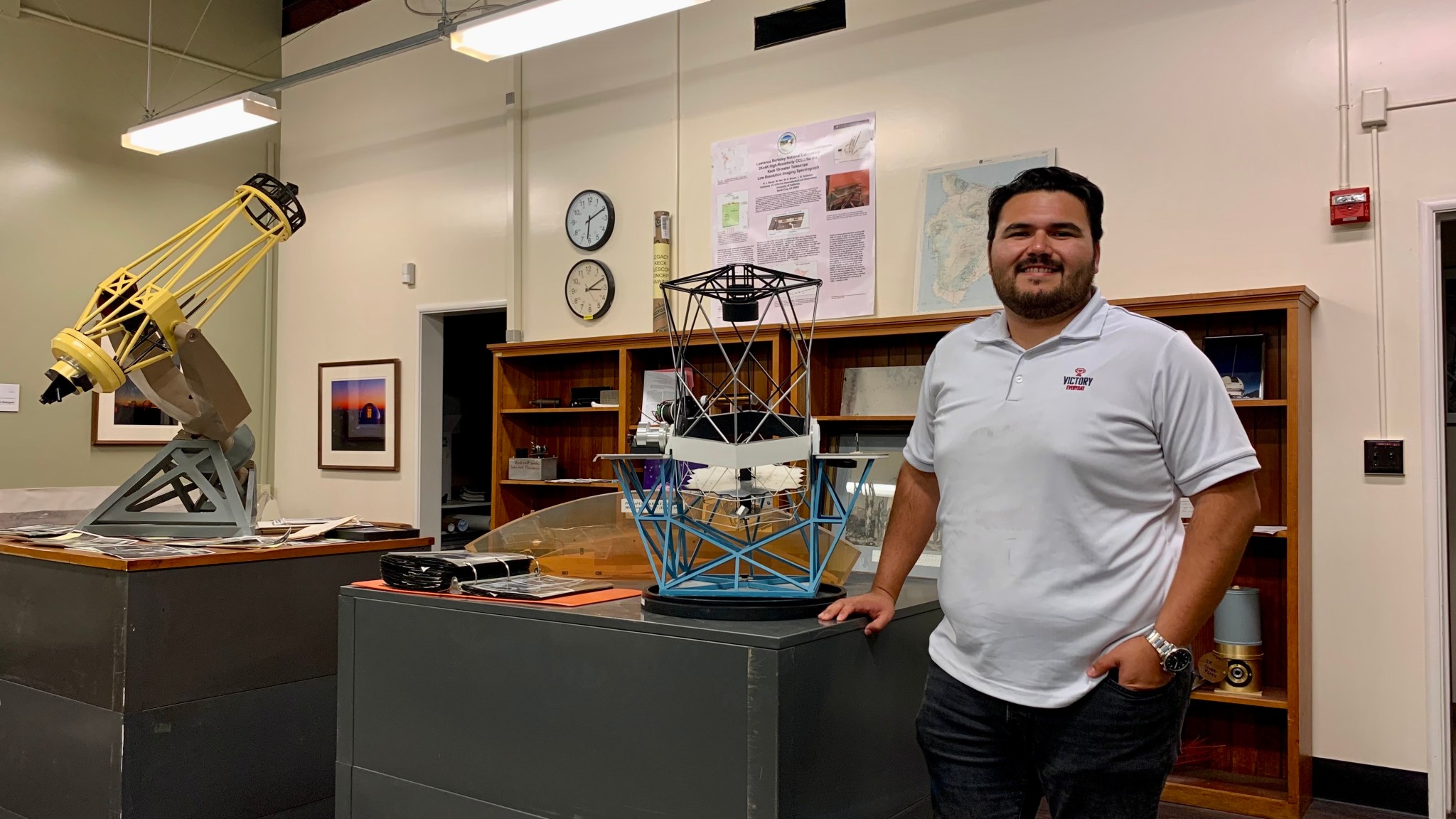 Cal Poly Pomona graduate Cristian Rodriguez in the lab at University of California Observatories (UCO) in Santa Cruz, the Shane telescope (model shown far left), and Hawaii’s Keck telescope (model on the right).