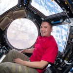 View of NASA astronaut Kjell Lindgren floating in front of the Cupola window.