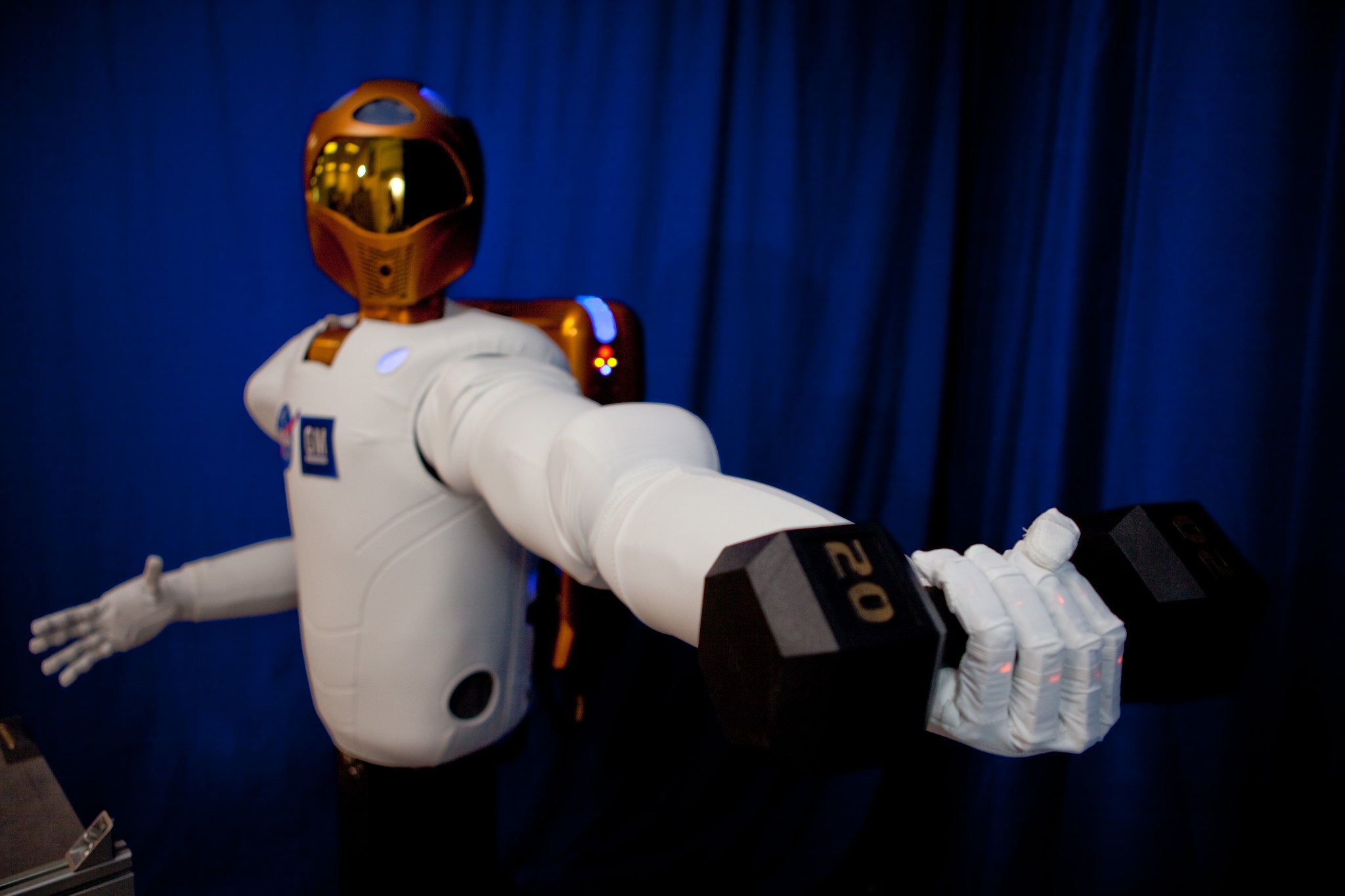 Robonaut lifting a weight in it's left arm.
