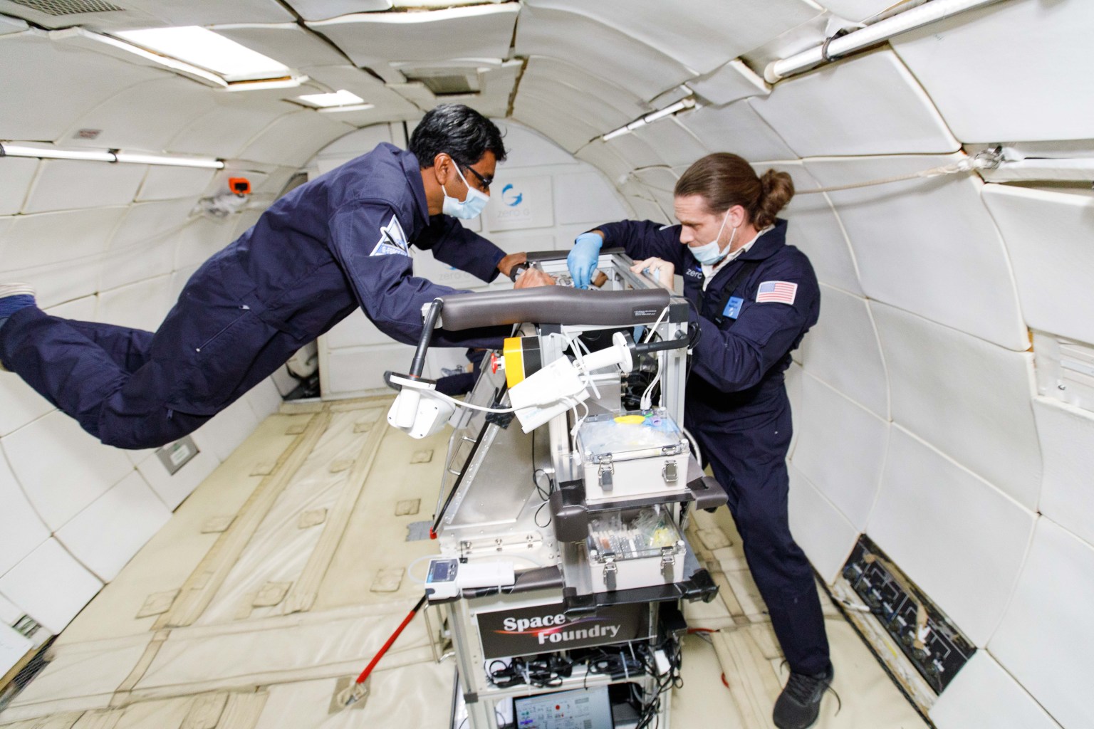 Space Foundry CEO and co-founder Dr. Ram Prasad Gandhiraman (left) and CTO and co-founder Dr. Dennis Nordlund operate the company’s plasma jet printing of electronics experiment in microgravity on a parabolic flight in December 2021