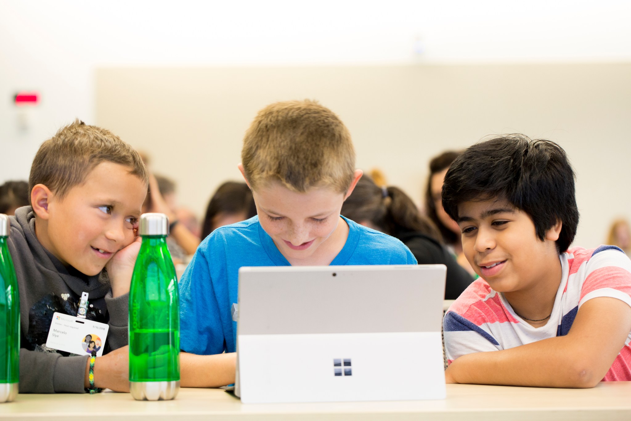 Three students sitting at a table looking at a computer screen.