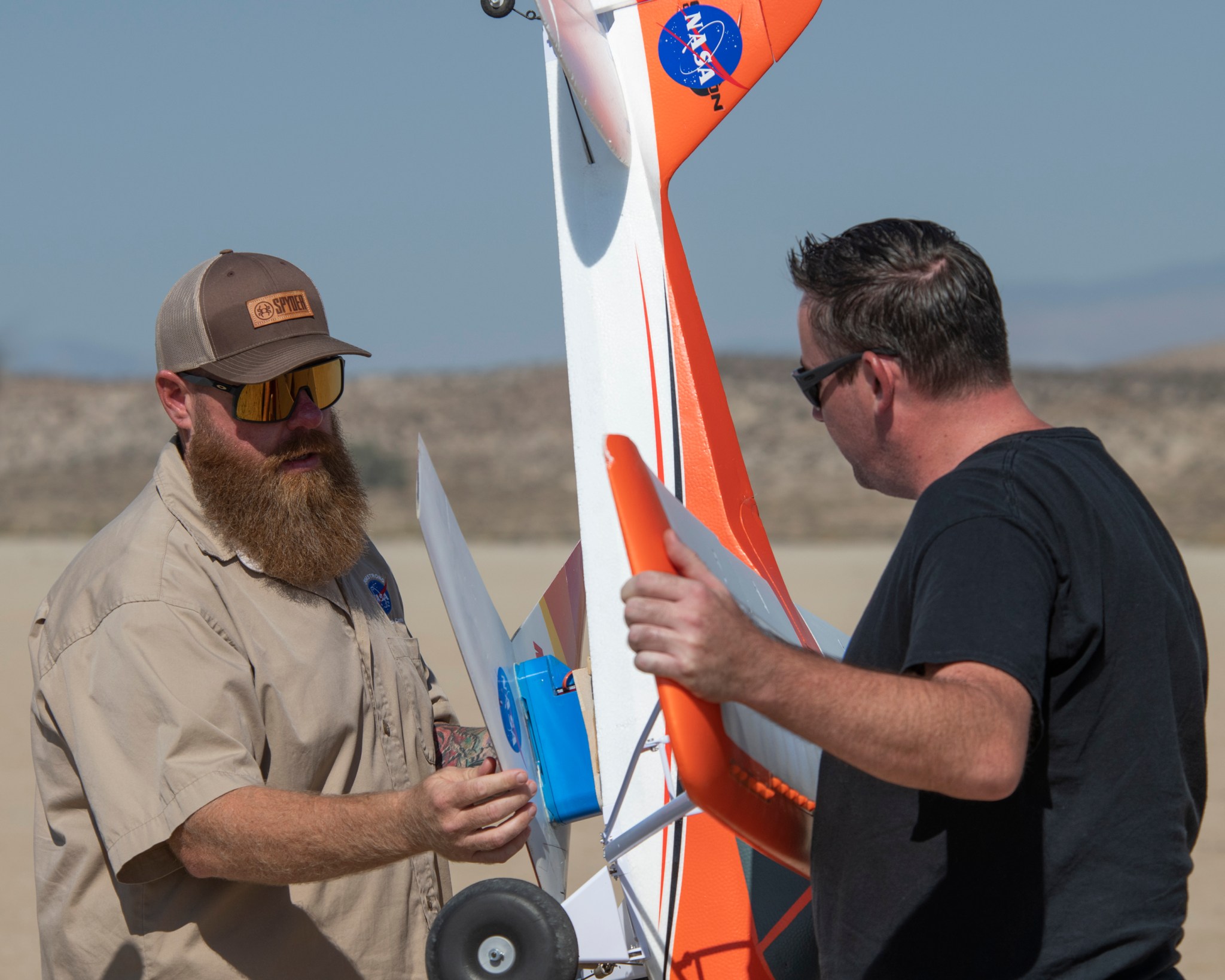 Justin Hall, left, attaches the Preliminary Research Aerodynamic Design to Land on Mars, or Prandtl-M, glider onto the Carbon-Z Cub, which Justin Link steadies. 