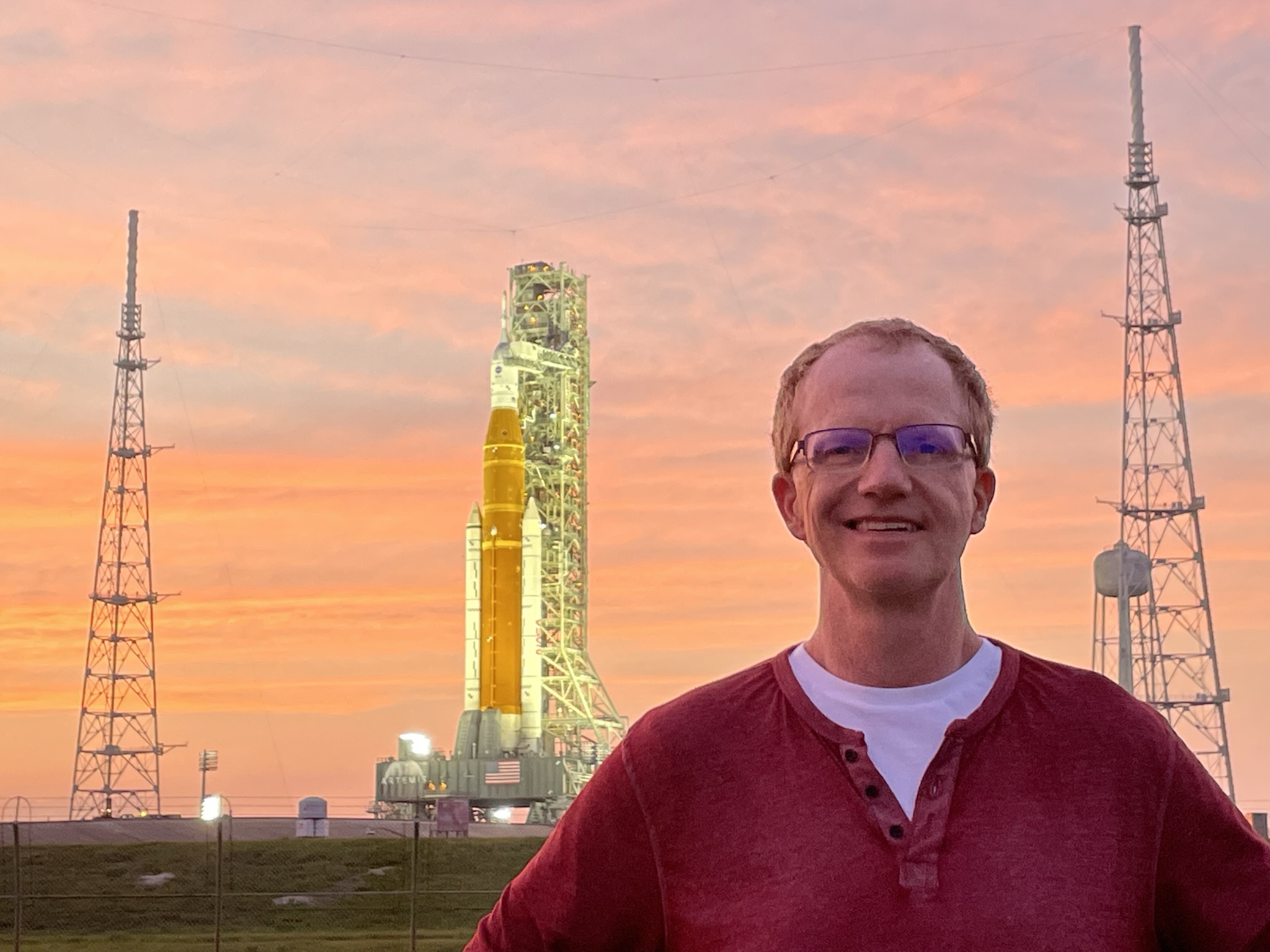 Brendan O Connell standing in front of SLS rocket.