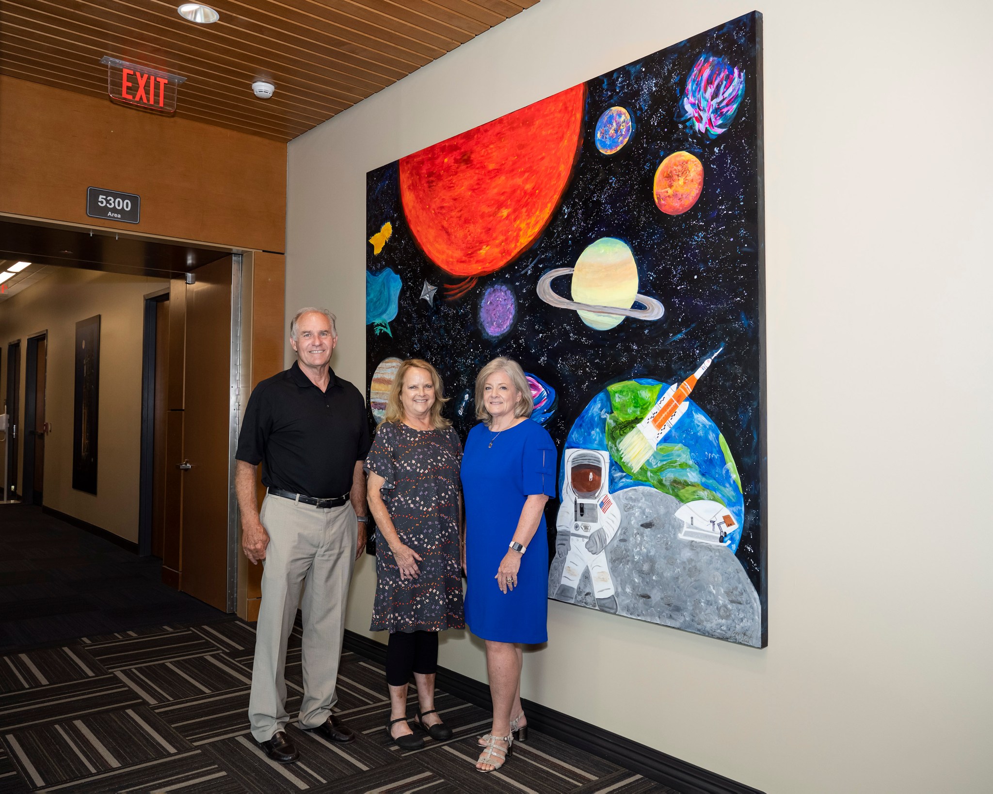 Steve and Pam Cash stand with Marshall Director Jody Singer, right, in front of the canvas they helped senior leaders create.