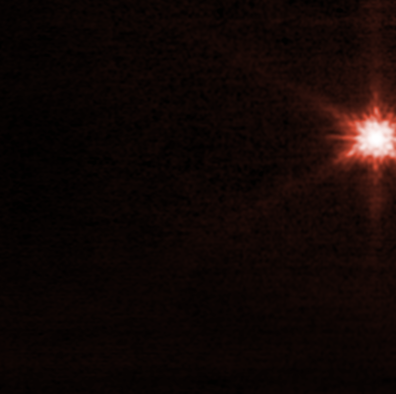 Animation of of Didymos-Dimorphos asteroid system after DART impact. This red-hued view from JWST shows a bright center and darker streaks radiating from it. Faint wisps appear to flow outward from the center over the course of the animation.