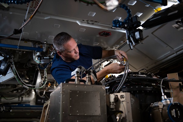 image of an astronaut working with experiment hardware