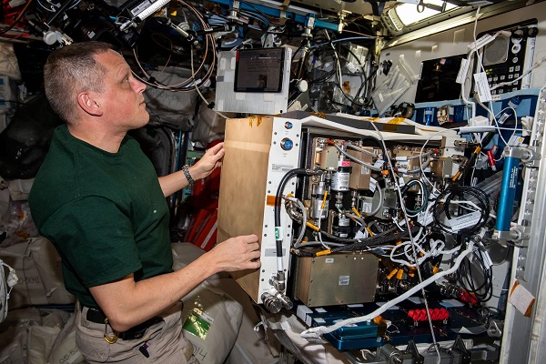 image of an astronaut working with experiment hardware