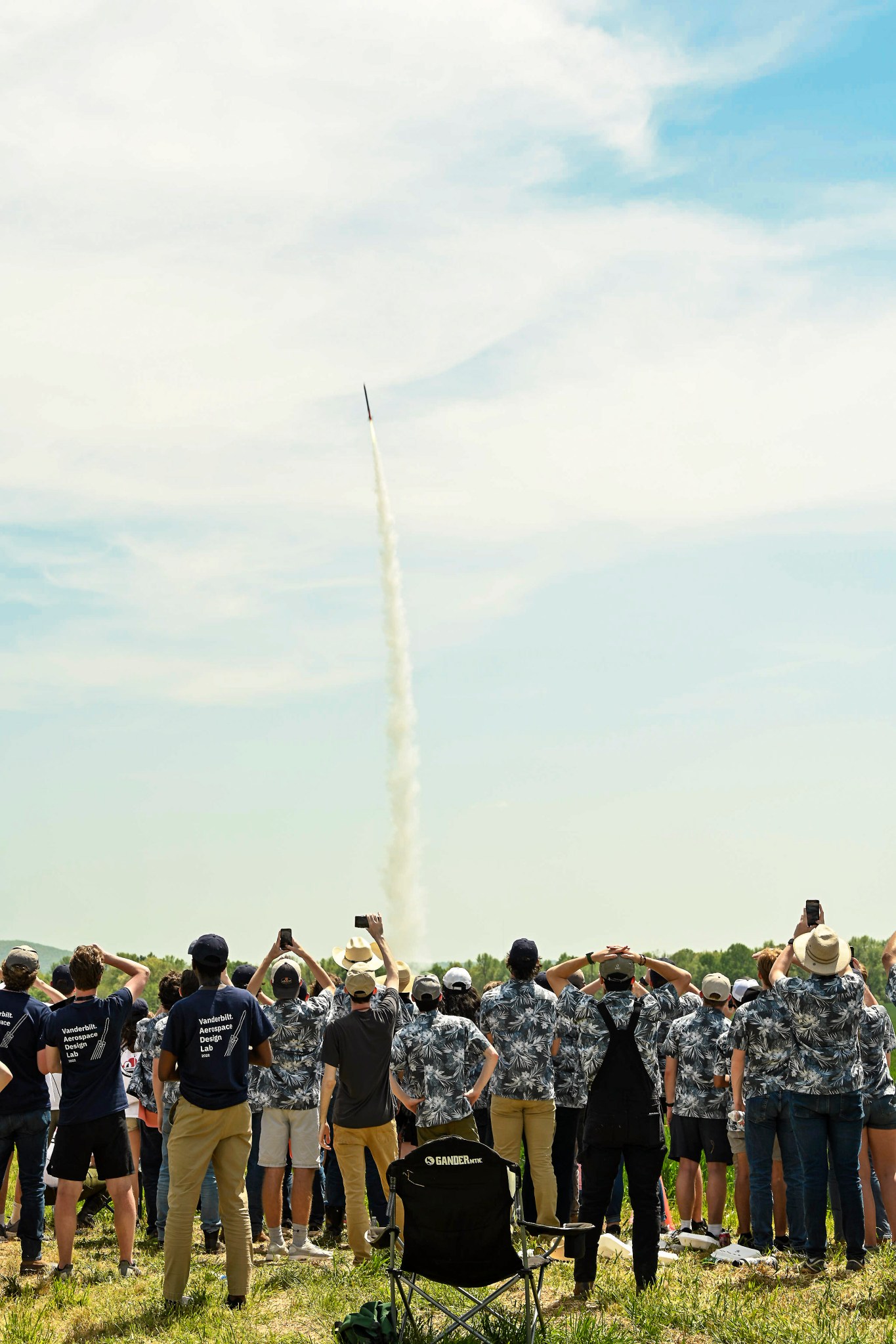 Competitors from NASA's 2022 Student Launch challenge observe a rocket launch at Bragg Farms in Toney, Alabama. 