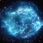 Composite images of the Cas A supernova remnant that looks like a spherical cloud resembles a hazy ball of turquoise and neon blue lightning, marbled with veins of gold.