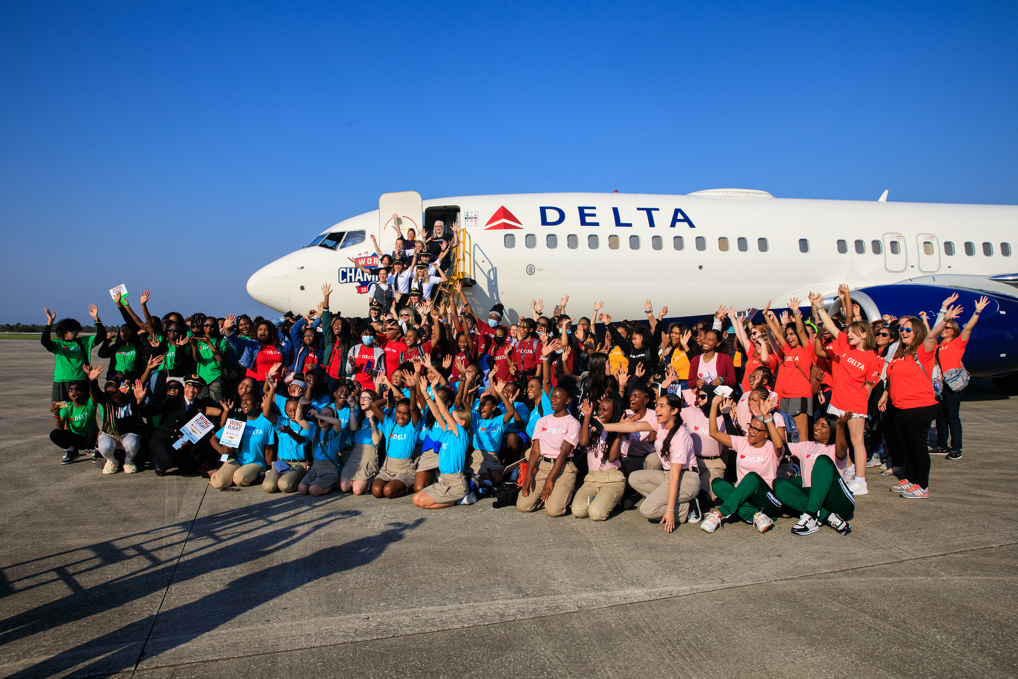 A group of all-female students is photographed in front of a Delta airplane at NASA's Kennedy Space Center in Florida following their arrival from Atlanta, Georgia.