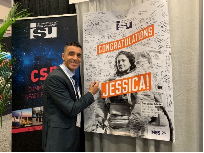 Fathi with a poster of a classmate, Jessica Meir, who is now a NASA Astronaut